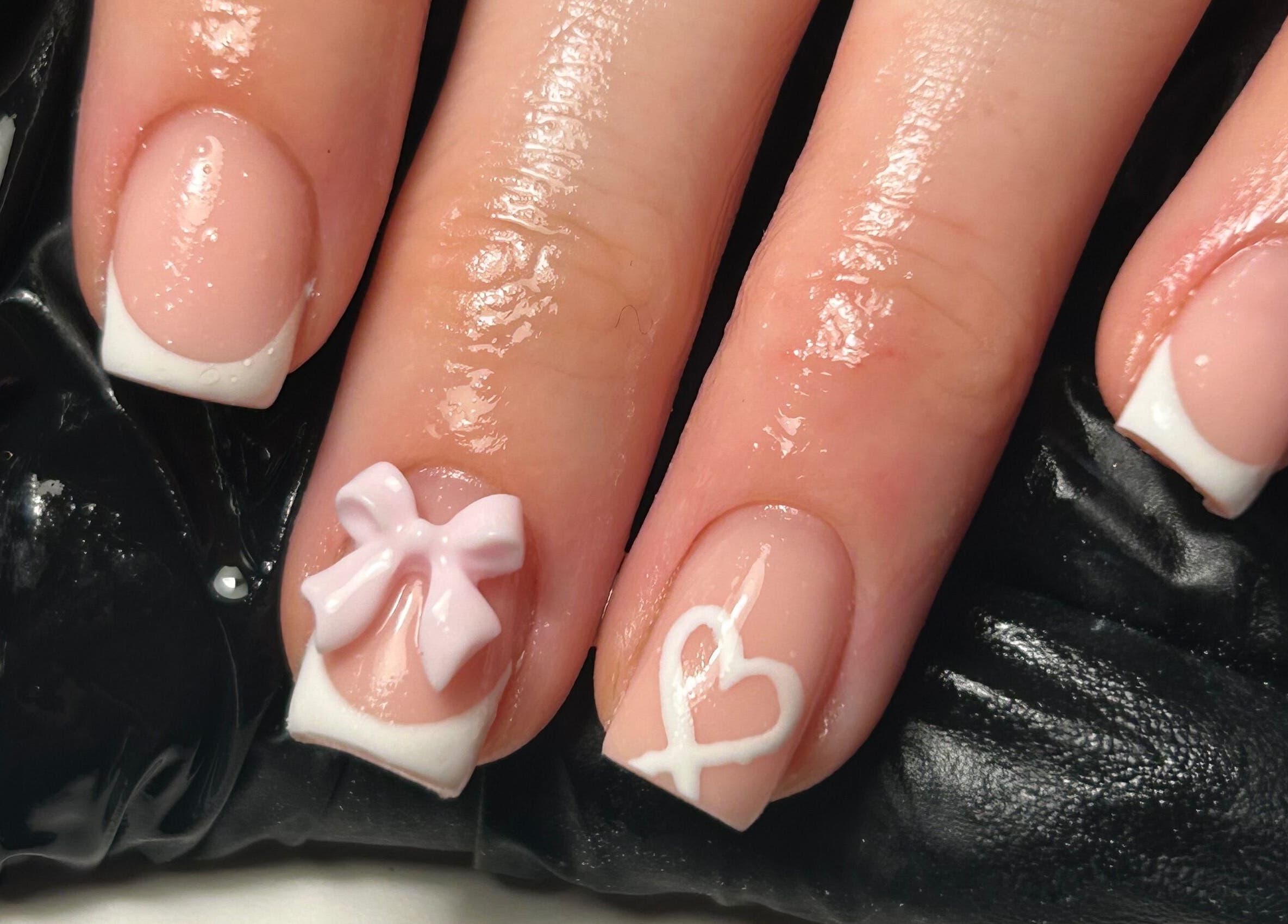 Elegant French manicure with bow and heart designs at The Beauty Q, Feering, England, GB.