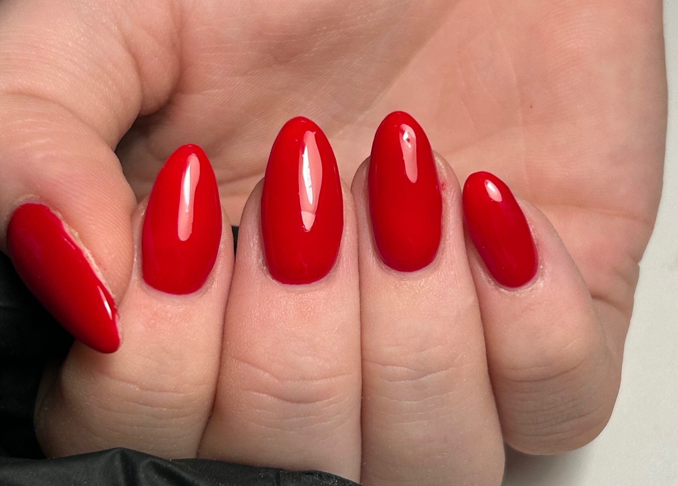 Red manicured nails at The Beauty Q, Feering, England, GB, showcasing expert nail artistry.