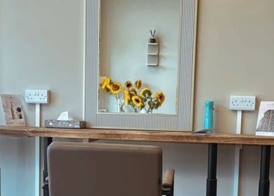 Bright styling station at Hairdressing by Alice, Rustington, England, GB, with fresh sunflowers and chic decor.
