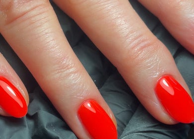 Bright red manicured nails at The Nail Garage, Frodsham, England, GB.