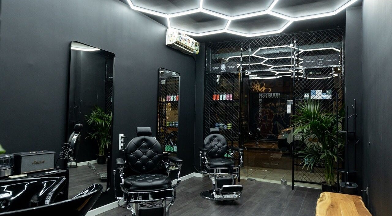 Κομψός χώρος κουρείου στο Rooster Negro, Θεσσαλονίκη, Θεσσαλονίκης, GR με πολυτελείς καθίσματα και καθρέφτες.