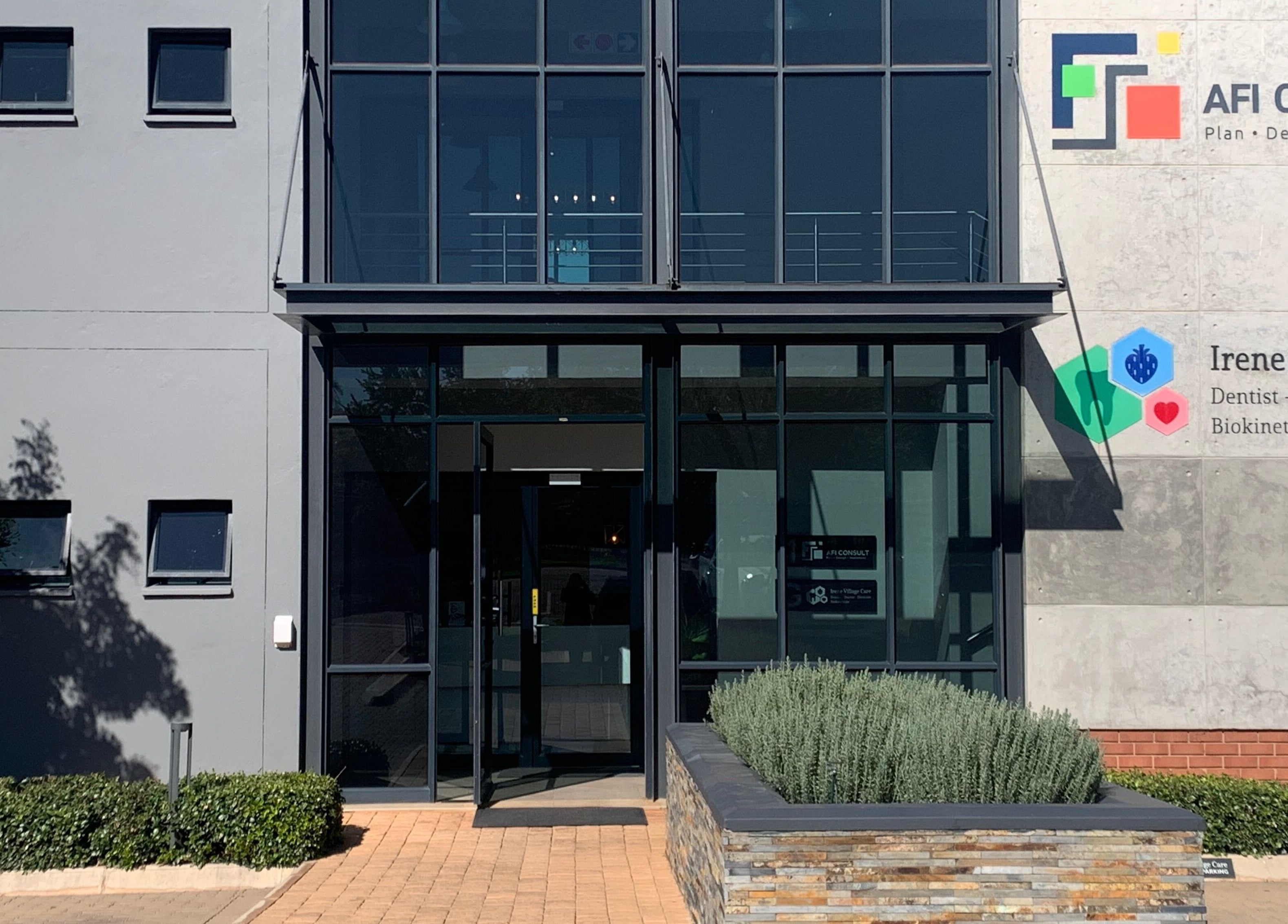 Modern building entrance of Serene Aesthetics in Centurion, Gauteng, ZA, showcasing sleek glass doors.