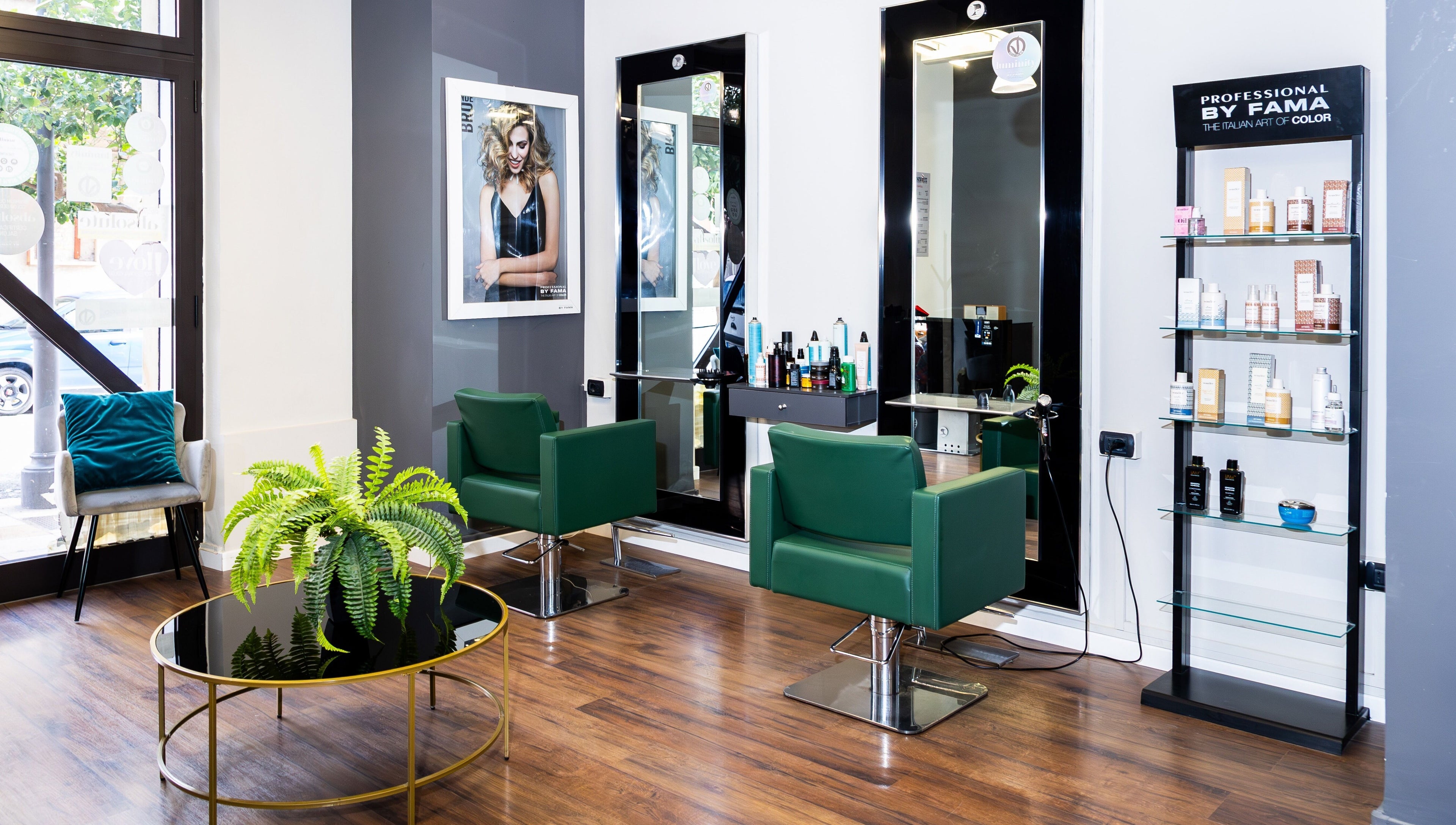 Interno di Lorenzo Carrozza, Parrucchiere & Barbiere a Roccella Ionica, Calabria, IT con sedie verdi e prodotti.