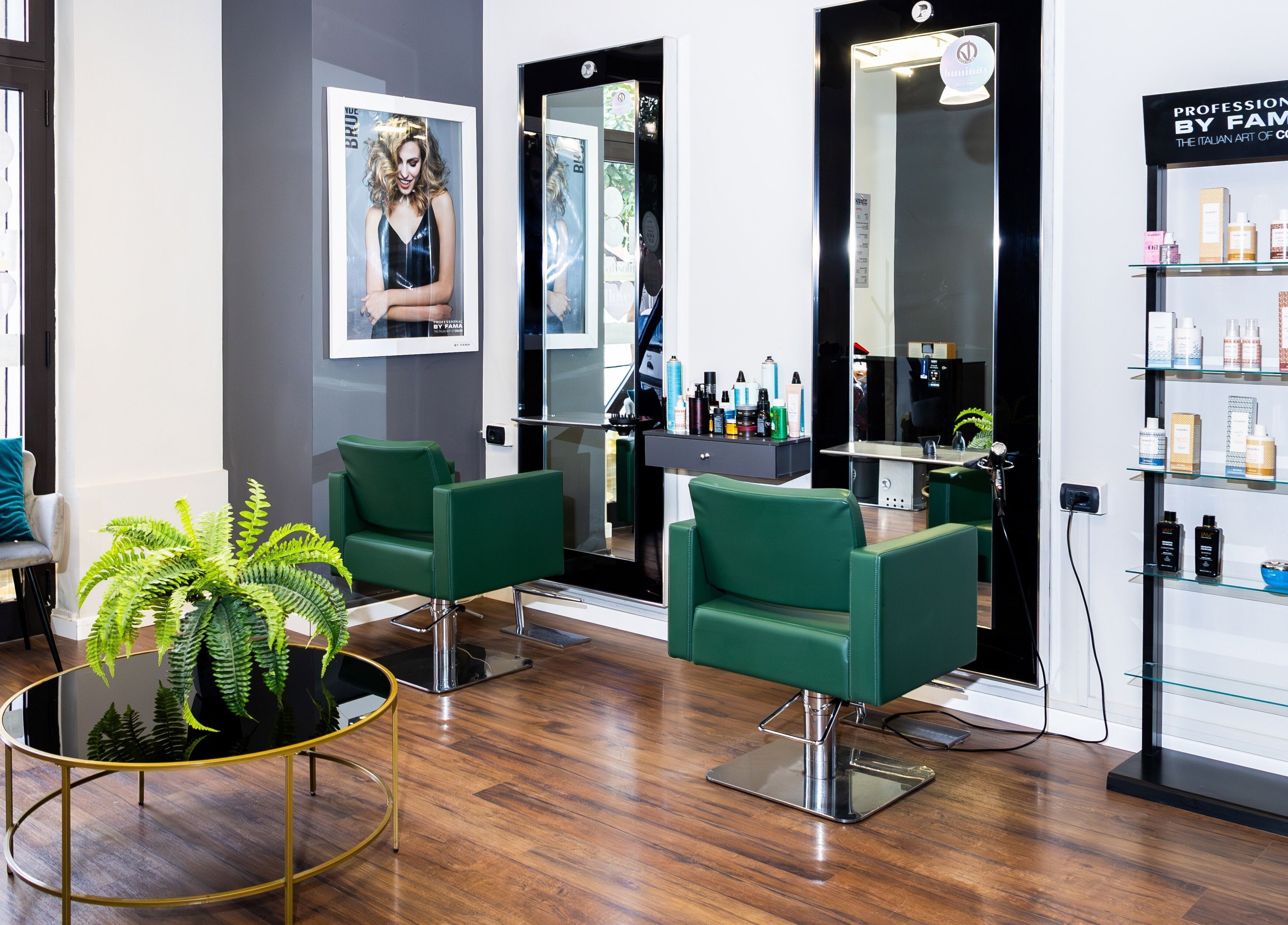 Interno di Lorenzo Carrozza, Parrucchiere & Barbiere a Roccella Ionica, Calabria, IT con sedie verdi e prodotti.