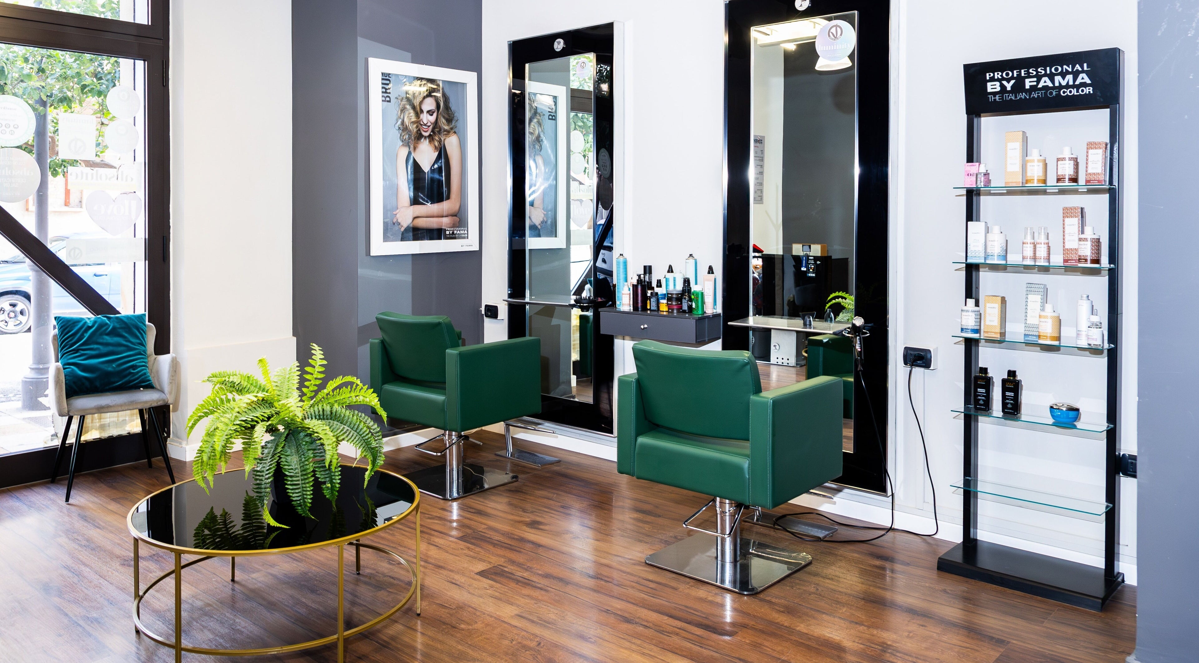 Interno di Lorenzo Carrozza, Parrucchiere & Barbiere a Roccella Ionica, Calabria, IT con sedie verdi e prodotti.