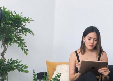 Mujer leyendo en una sala moderna en KEREN HAPUC, Vigo, ES rodeada de plantas.