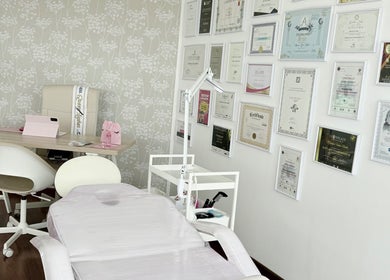 Sala elegante en KEREN HAPUC, Vigo, ES con diplomas en la pared y silla de estética profesional.