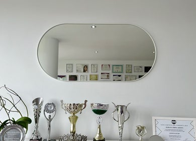 Troféus y certificaciones de KEREN HAPUC, Vigo, ES, reflejados en espejo moderno.