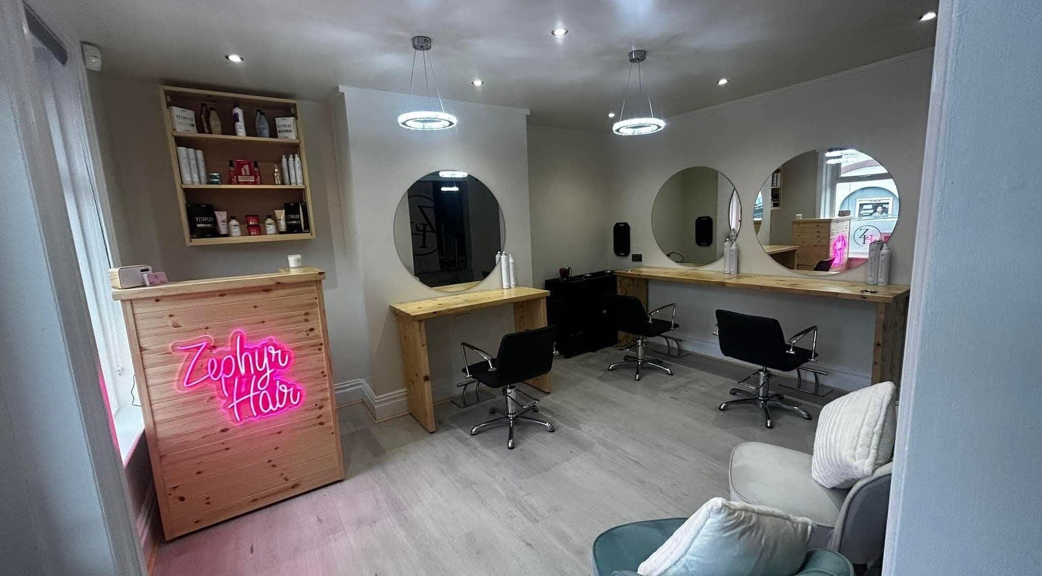 Modern salon interior at Hair by Kadey, Elland, England, GB with stylish seating and mirrors.