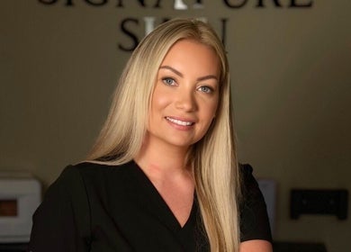 Friendly staff member at Signature Skin, Taverham, England, GB, welcoming guests with a warm smile.