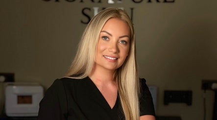Friendly staff member at Signature Skin, Taverham, England, GB, welcoming guests with a warm smile.