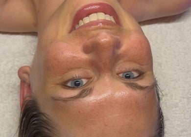 Smiling client enjoying facial at Signature Skin, Taverham, England, GB.