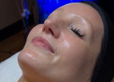 Woman enjoying a facial at Signature Skin, Taverham, England, GB, showcasing her smooth, glowing skin.