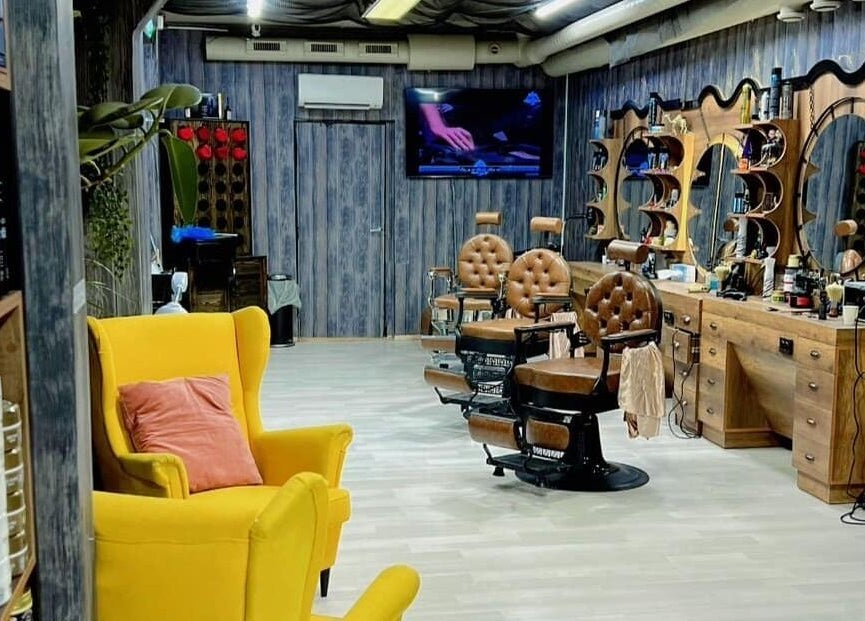 Interiør i Klepp Barbershop & Frisør, Kleppe, Rogaland, NO med stilfulle stoler og elegant treinnredning.