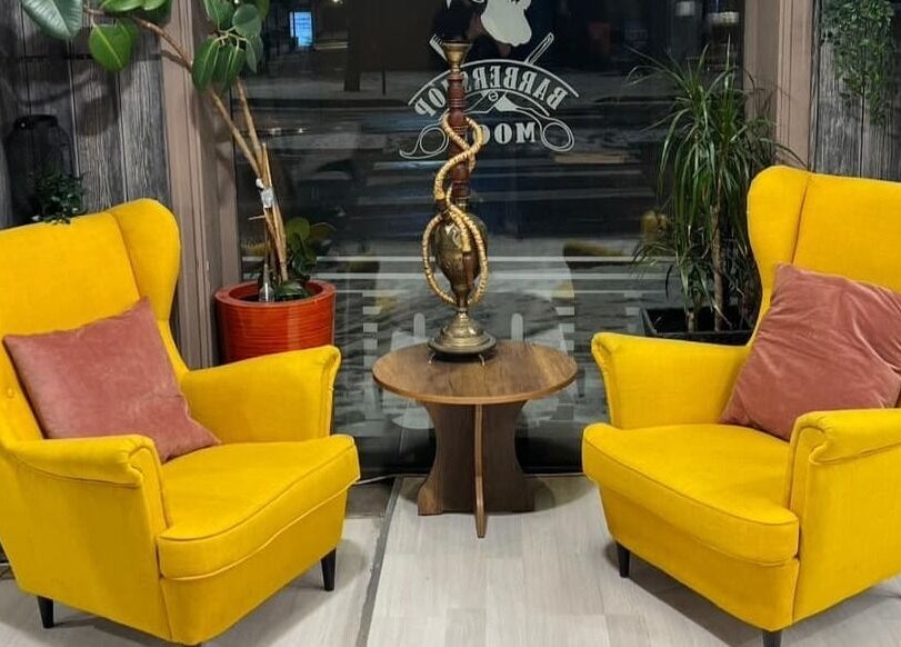 Komfortabelt loungeområde hos Klepp Barbershop & Frisør i Kleppe, Rogaland, NO med gulbeige stoler.