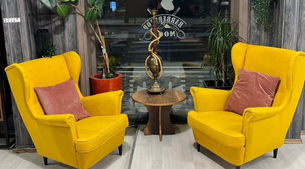 Komfortabelt loungeområde hos Klepp Barbershop & Frisør i Kleppe, Rogaland, NO med gulbeige stoler.