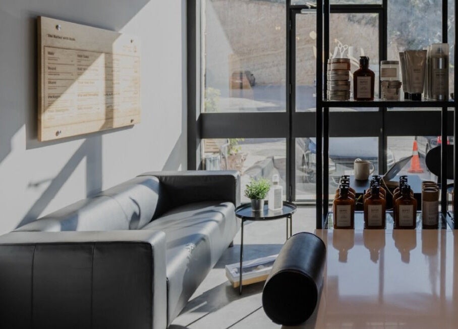 Stylish interior of Yousef Afandi Barbershop - Al Sahafa, Riyadh, Riyadh Province, SA, with comfortable seating and products.