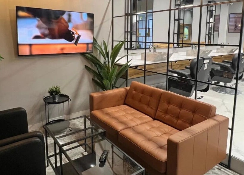 Modern waiting area in Yousef Afandi Barbershop - Al Sahafa, Riyadh with stylish seating and decor.