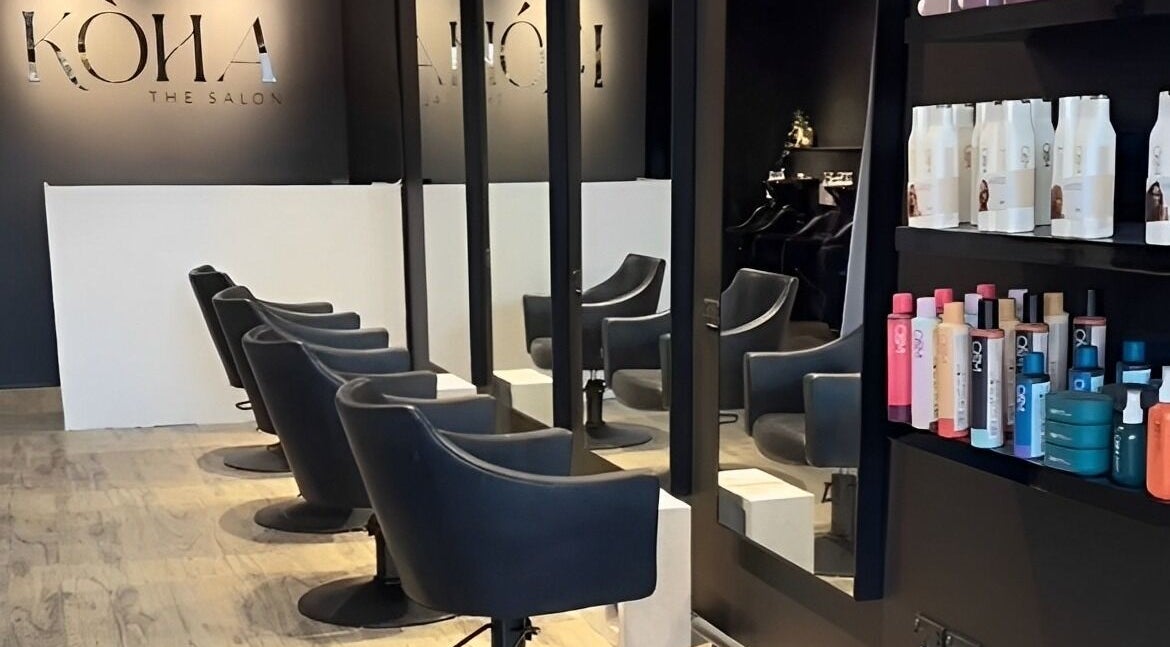 Interior of Koha The Salon CORINDA in Corinda, Queensland, AU with sleek chairs and hair products on shelves.
