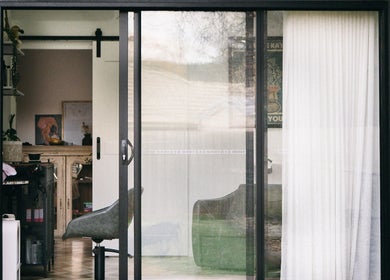 Interior view of Hair By Vanessa salon in Gisborne, Victoria, AU through glass doors showcasing a stylish chair.