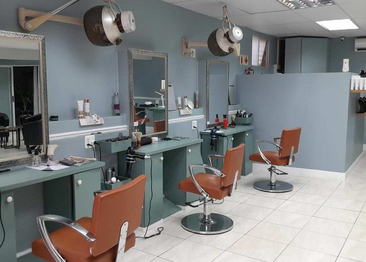 Elegant salon interior at Tippin's in Makhanda, Eastern Cape, ZA featuring stylish chairs and workstations.