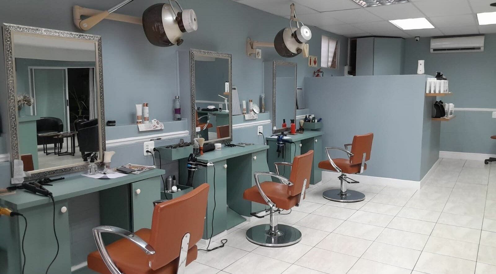 Elegant salon interior at Tippin's in Makhanda, Eastern Cape, ZA featuring stylish chairs and workstations.