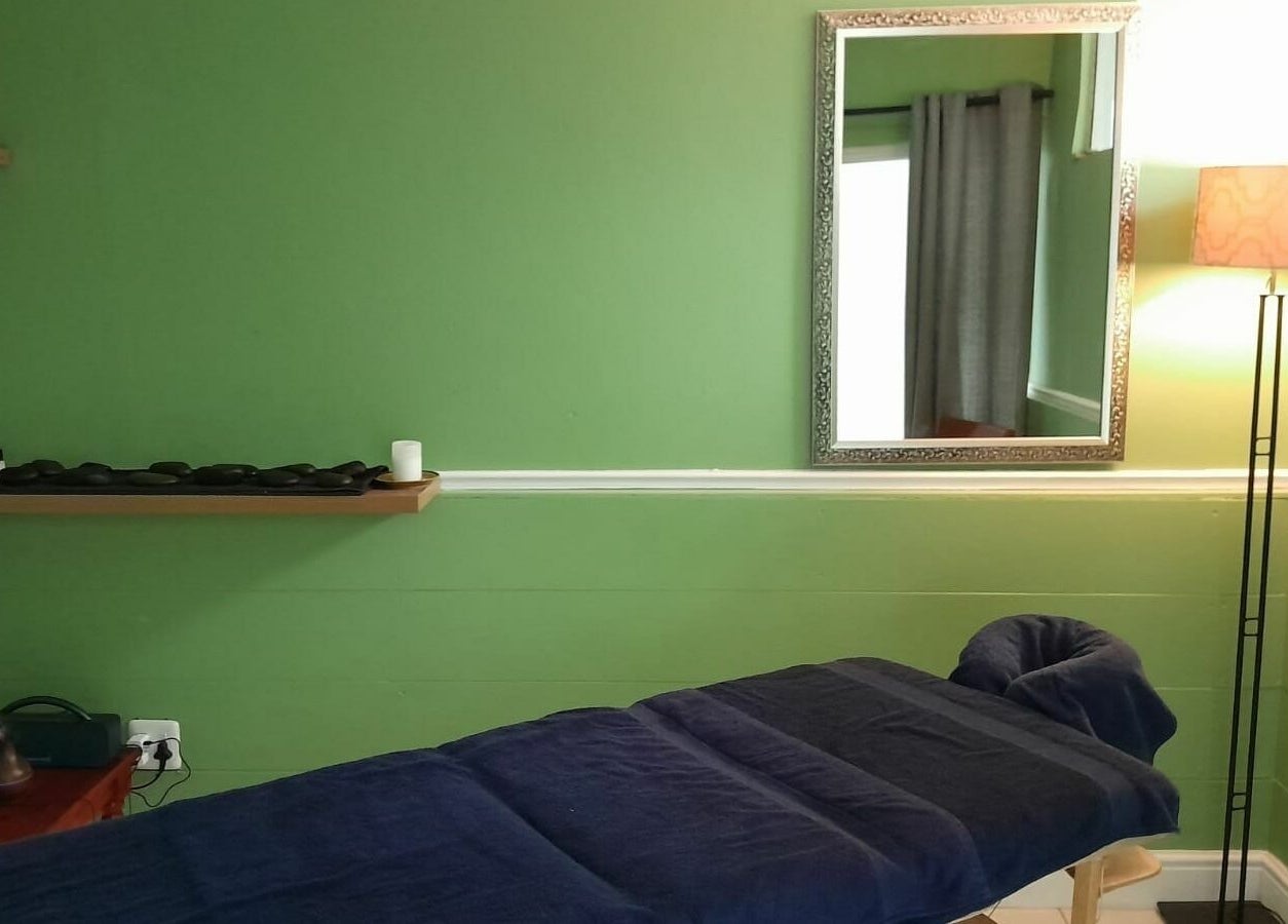 Relaxing spa room at Tippin's, Makhanda, Eastern Cape, ZA with calming green walls and massage table.