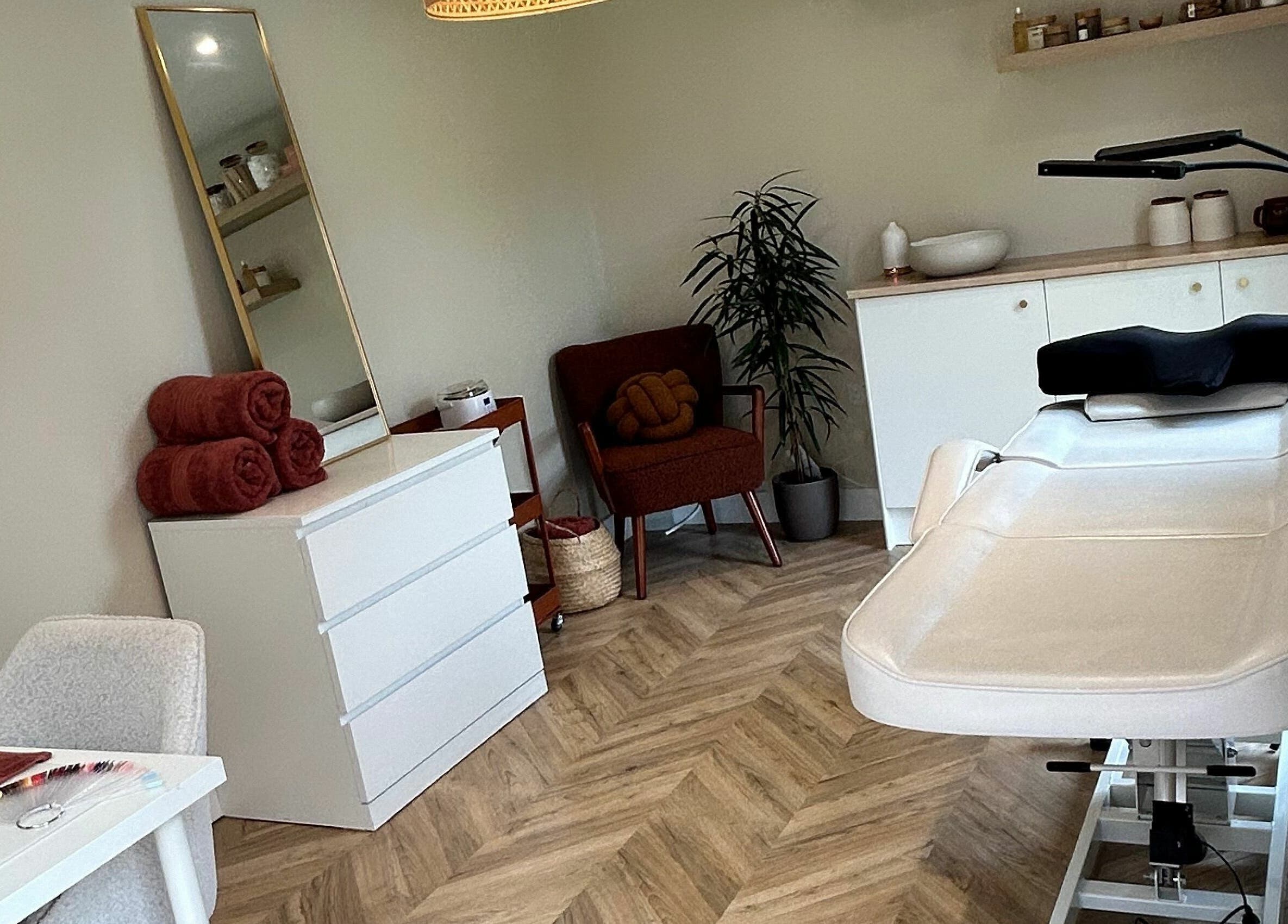 Relaxing treatment room at Beauty at Bullrush, Standish, England, GB, featuring a white therapy bed and cozy decor.