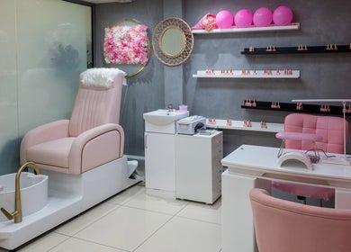 Elegant interior of Geri Nails Art Studio, London, England, GB, featuring plush pink chairs and stylish decor.