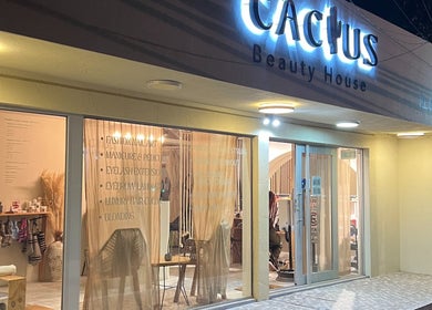 Fachada iluminada de Cactus Beauty House en San Jose del Cabo, Baja California Sur, MX, mostrando servicios estéticos.