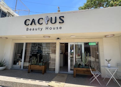Fachada de Cactus Beauty House en San Jose del Cabo, Baja California Sur, MX, con sillas y mesas blancas.