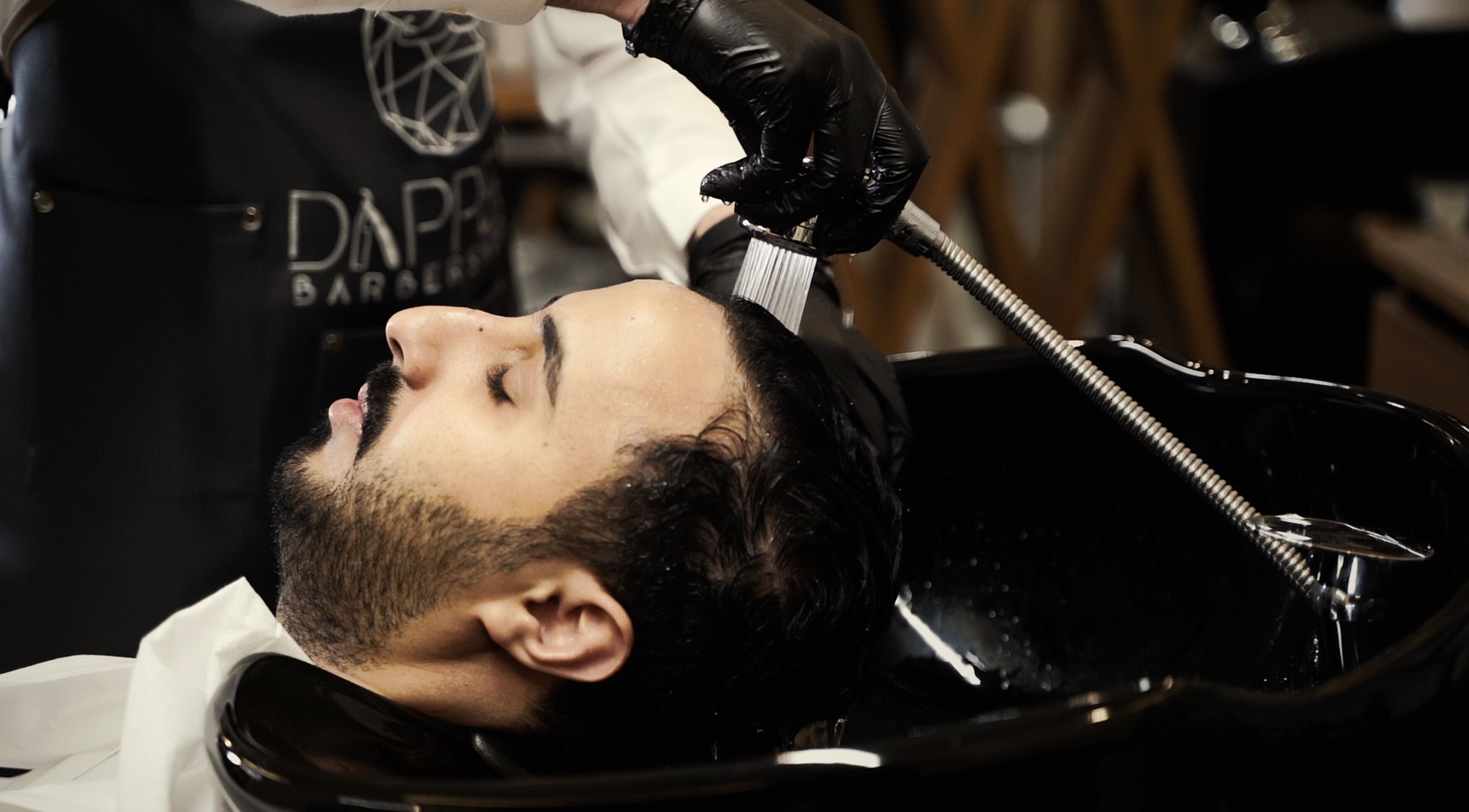 Client enjoys a soothing hair wash at Dapper Barbershop in Dhahran, Eastern Province, SA.
