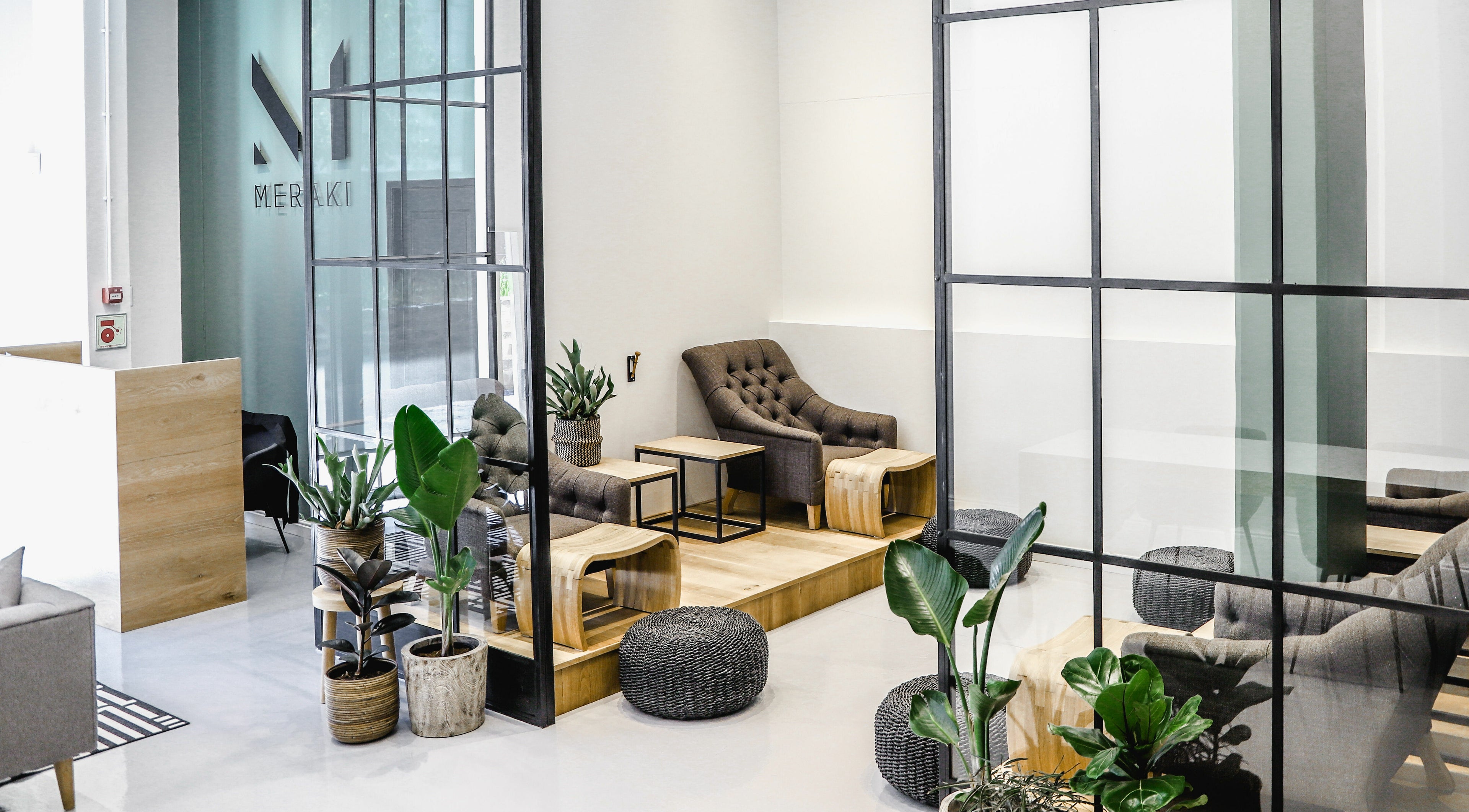Elegant lounge area at Meraki Aesthetics, Cape Town, Western Cape, ZA with modern decor and lush plants.