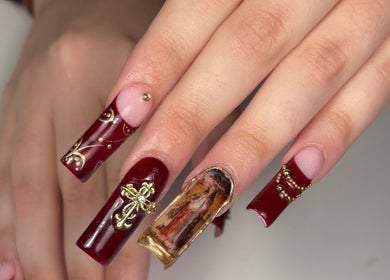 Manicura artística en rojo y oro en Nails by Caprii, Avilés, ES.