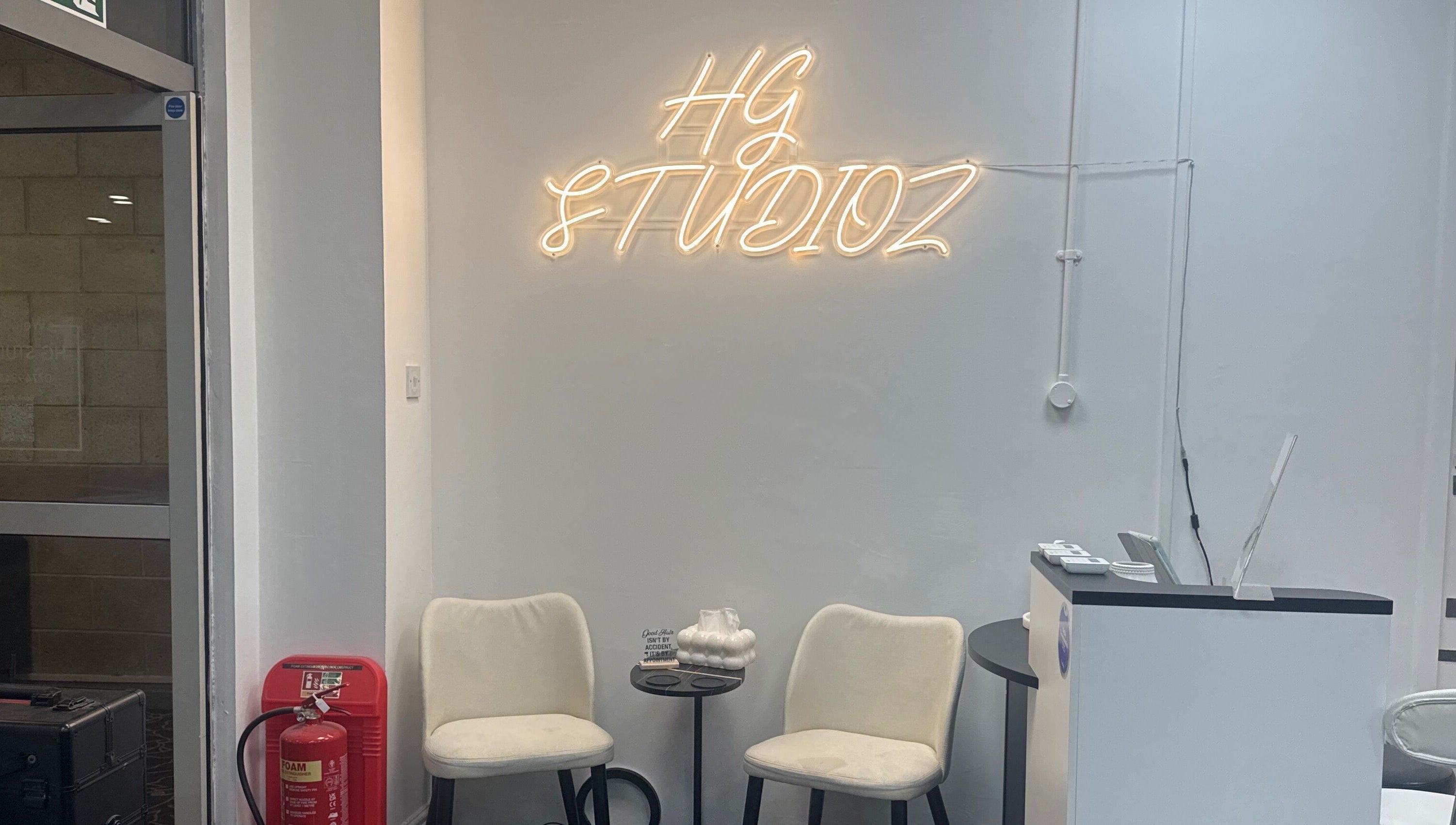 HG Studioz reception area with seating and neon sign in South, England, GB.