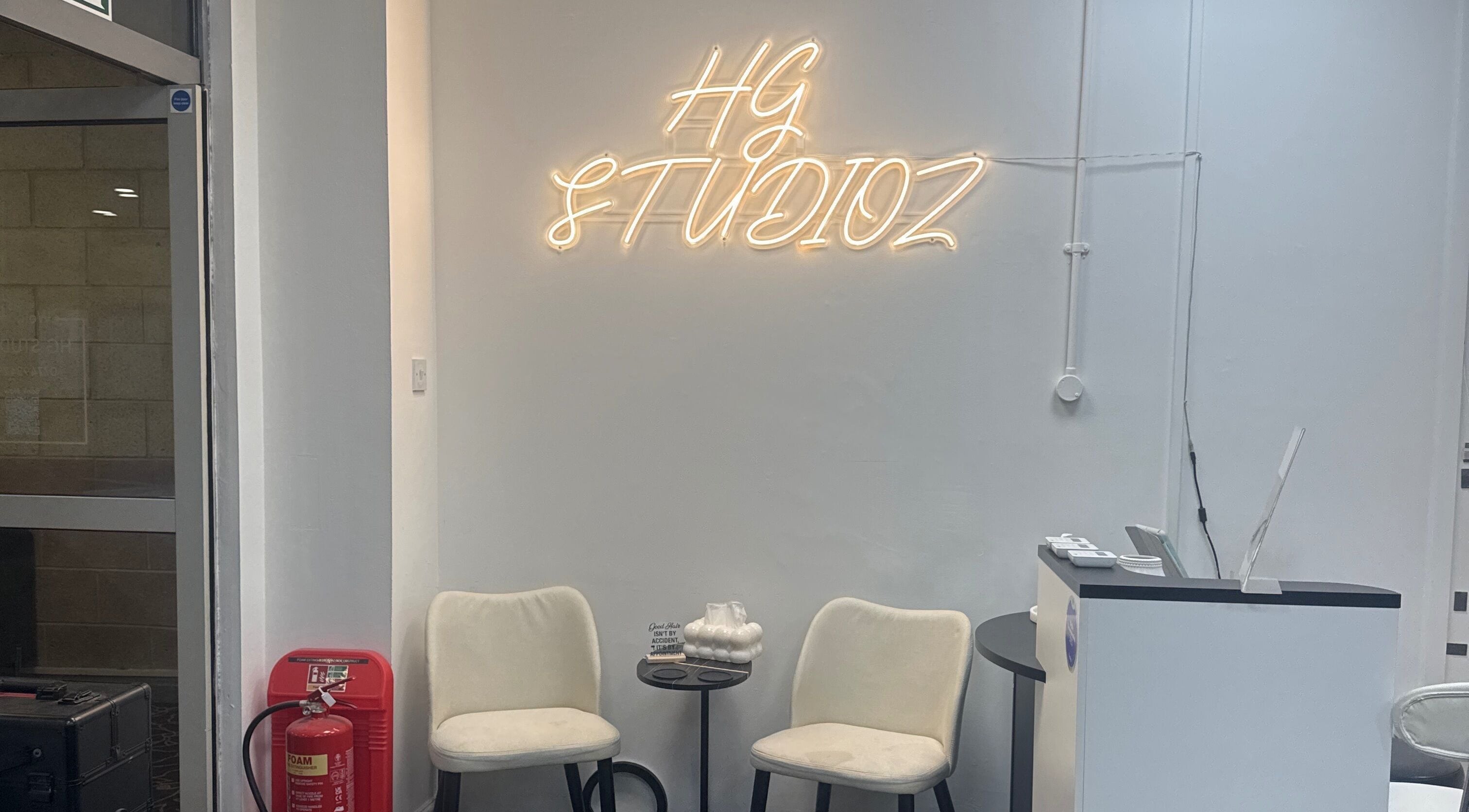 HG Studioz reception area with seating and neon sign in South, England, GB.