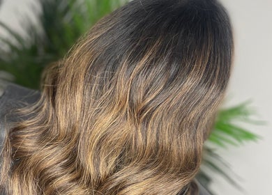 Stylish wavy brown hair at HG Studioz, South, England, GB, styled with precision amidst a serene backdrop.