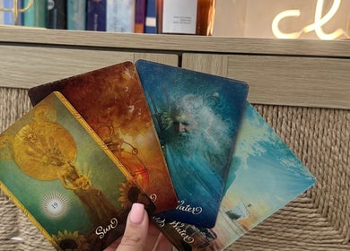 A hand holding tarot cards at Serenity Seven, Hamilton, Scotland, GB, capturing a mystical and serene ambiance.