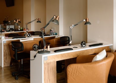 Elegant nail stations at The Nail Bar in Shrewsbury, Massachusetts, US with stylish chairs and lamps.