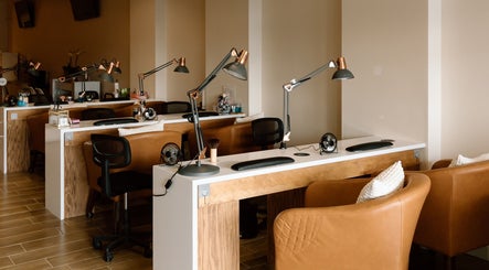 Elegant nail stations at The Nail Bar in Shrewsbury, Massachusetts, US with stylish chairs and lamps.