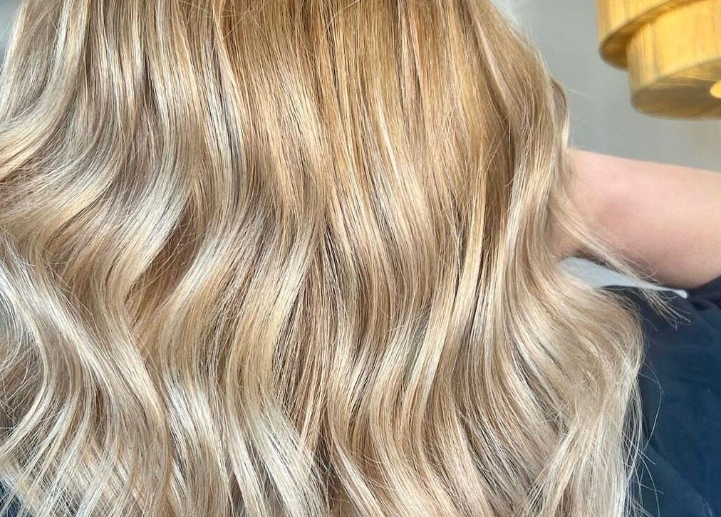 Lustrous blonde waves styled at BAE Salon in Woolooware, New South Wales, AU, showcasing expert hair treatment.