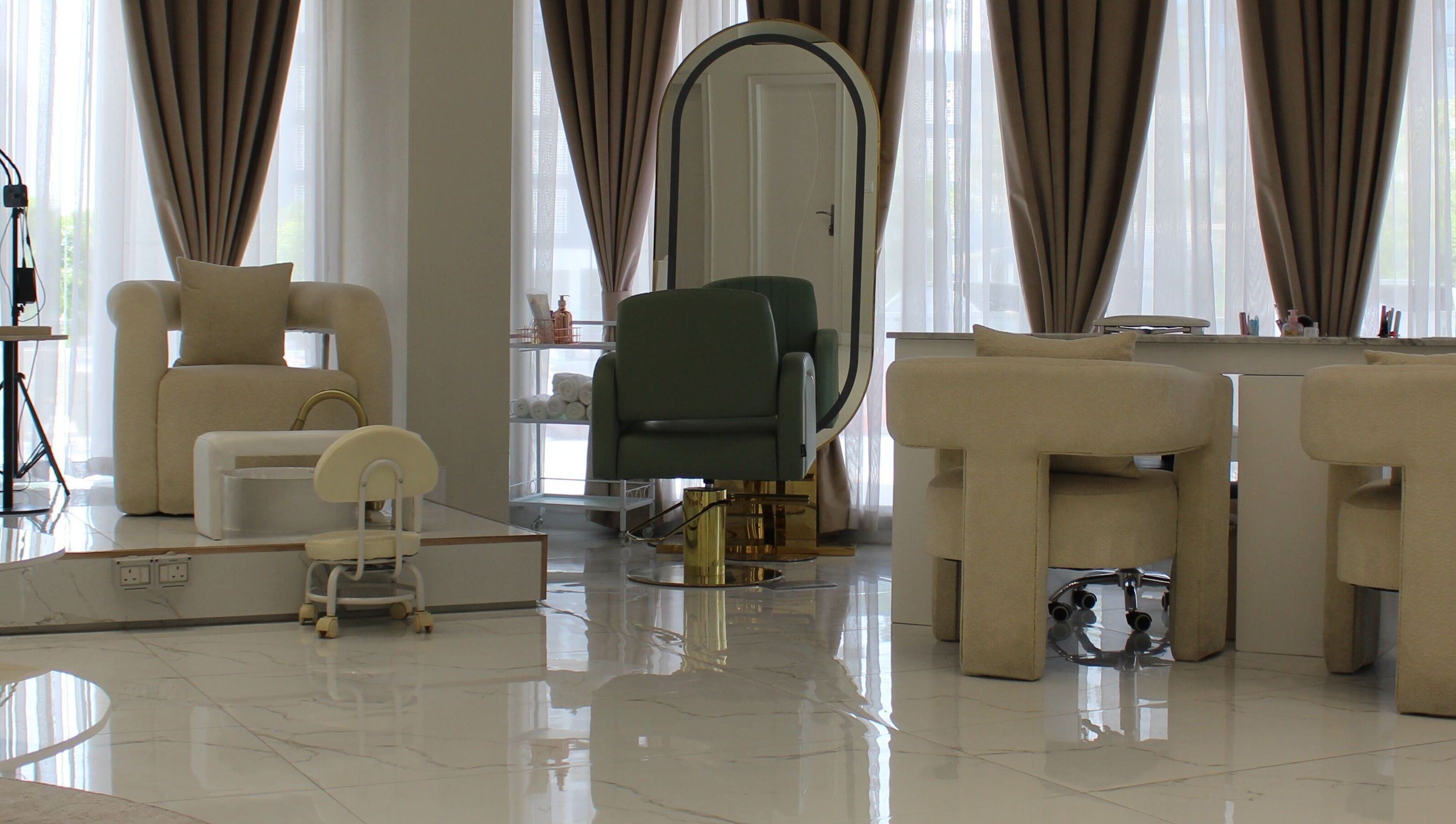 Chic interior of Palm Aura Beauty Salon, Dubai, featuring elegant seating and large mirror.