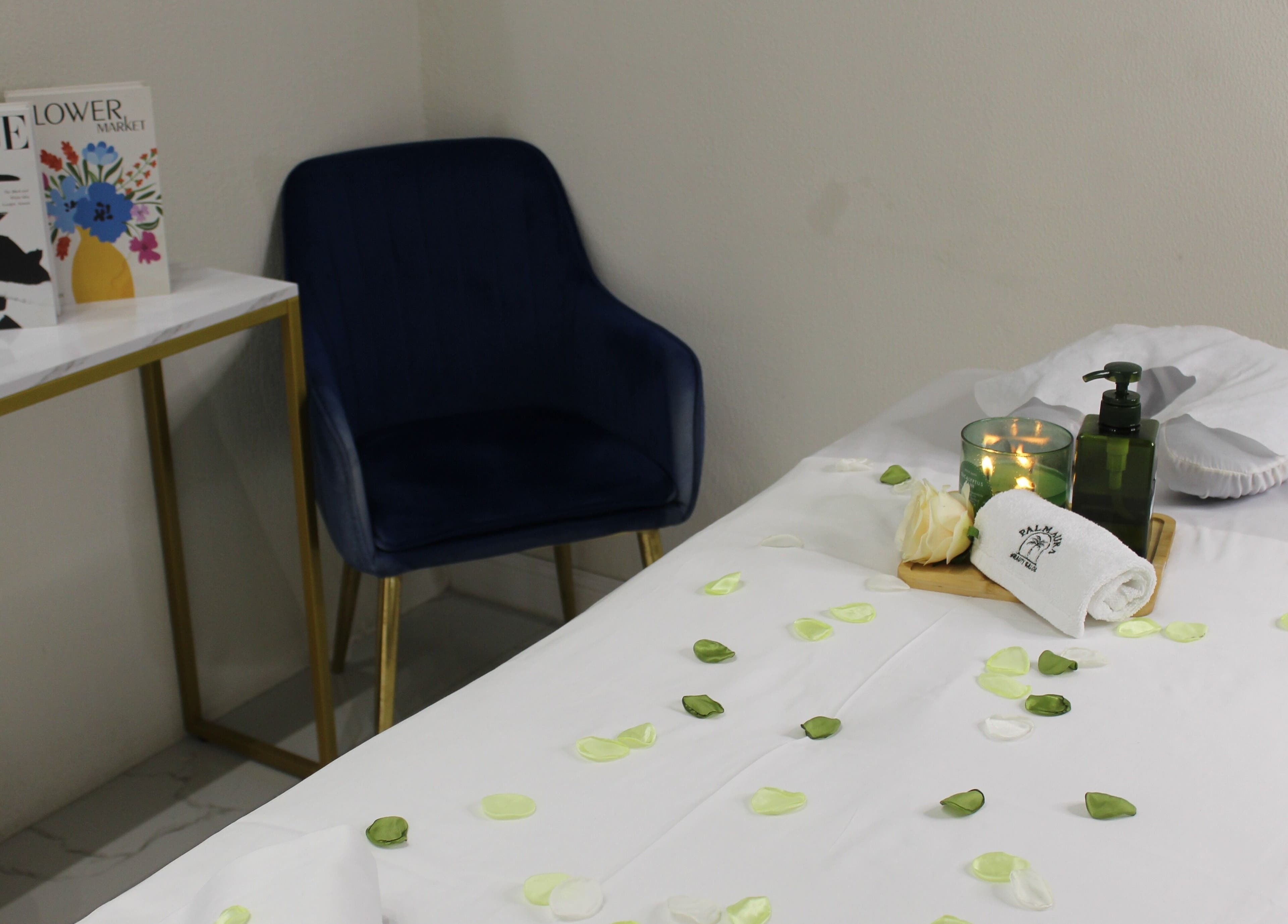 Tranquil massage table set up at Palm Aura Beauty Salon, Dubai, Dubai, AE with elegant decor and petals.