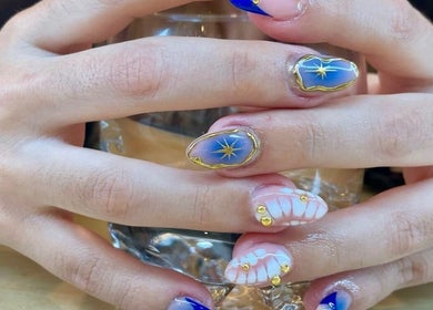 Diseño de uñas estelar en Calma Nail Bar - Condesa, Ciudad De México, MX. Decoradas con detalles dorados elegantes.