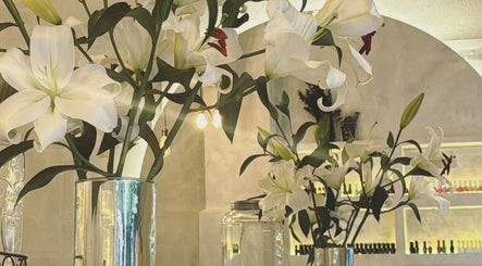 Interiores de Calma Nail Bar - Condesa en Ciudad De México con lirios blancos en jarrones.
