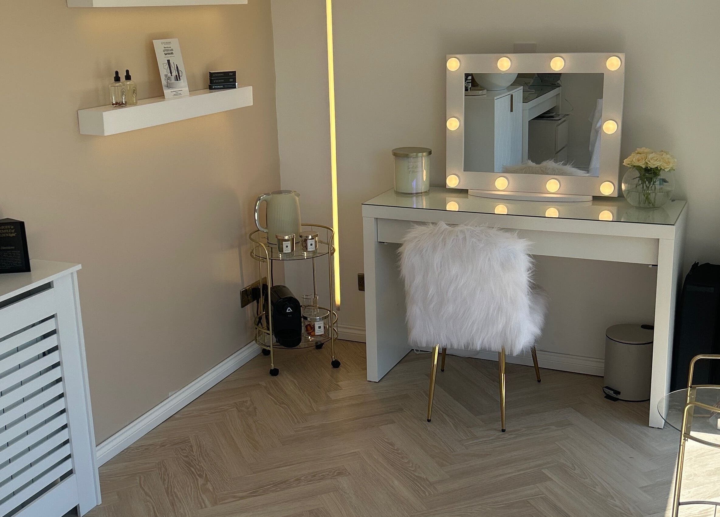 Chic vanity at The Beauty Atelier Stalbans, St Albans, England, GB with lighted mirror and fluffy chair.
