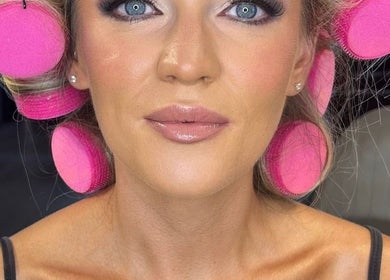 Woman with pink hair rollers ready for beauty treatment at Gloss Glo & Blo in Paisley, Scotland, GB.