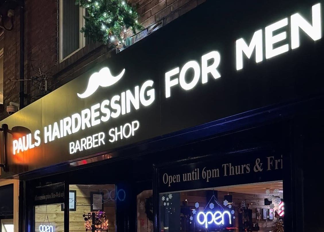 Illuminated sign of Paul's Hairdressing for Men in Wallsend, England, GB at night.