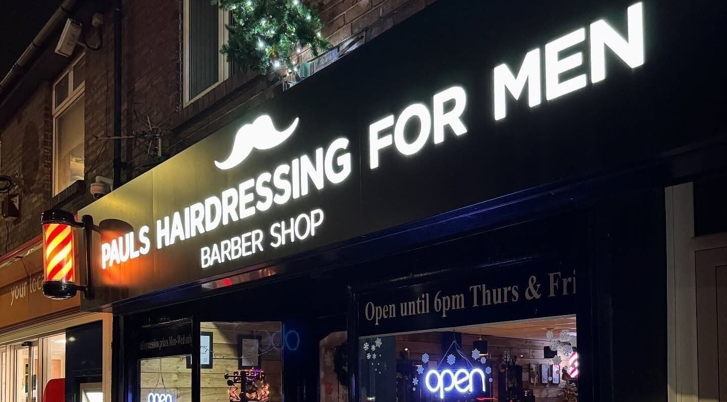 Illuminated sign of Paul's Hairdressing for Men in Wallsend, England, GB at night.