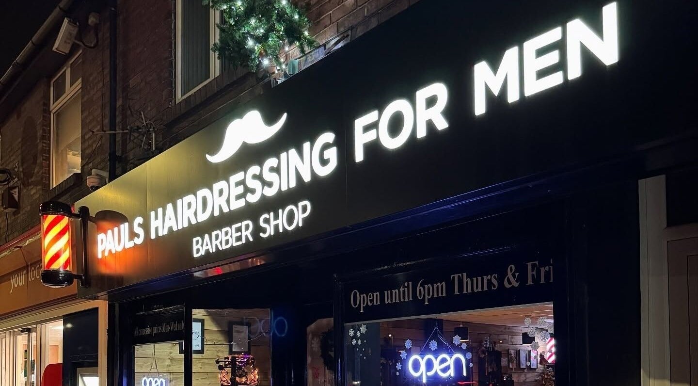 Illuminated sign of Paul's Hairdressing for Men in Wallsend, England, GB at night.